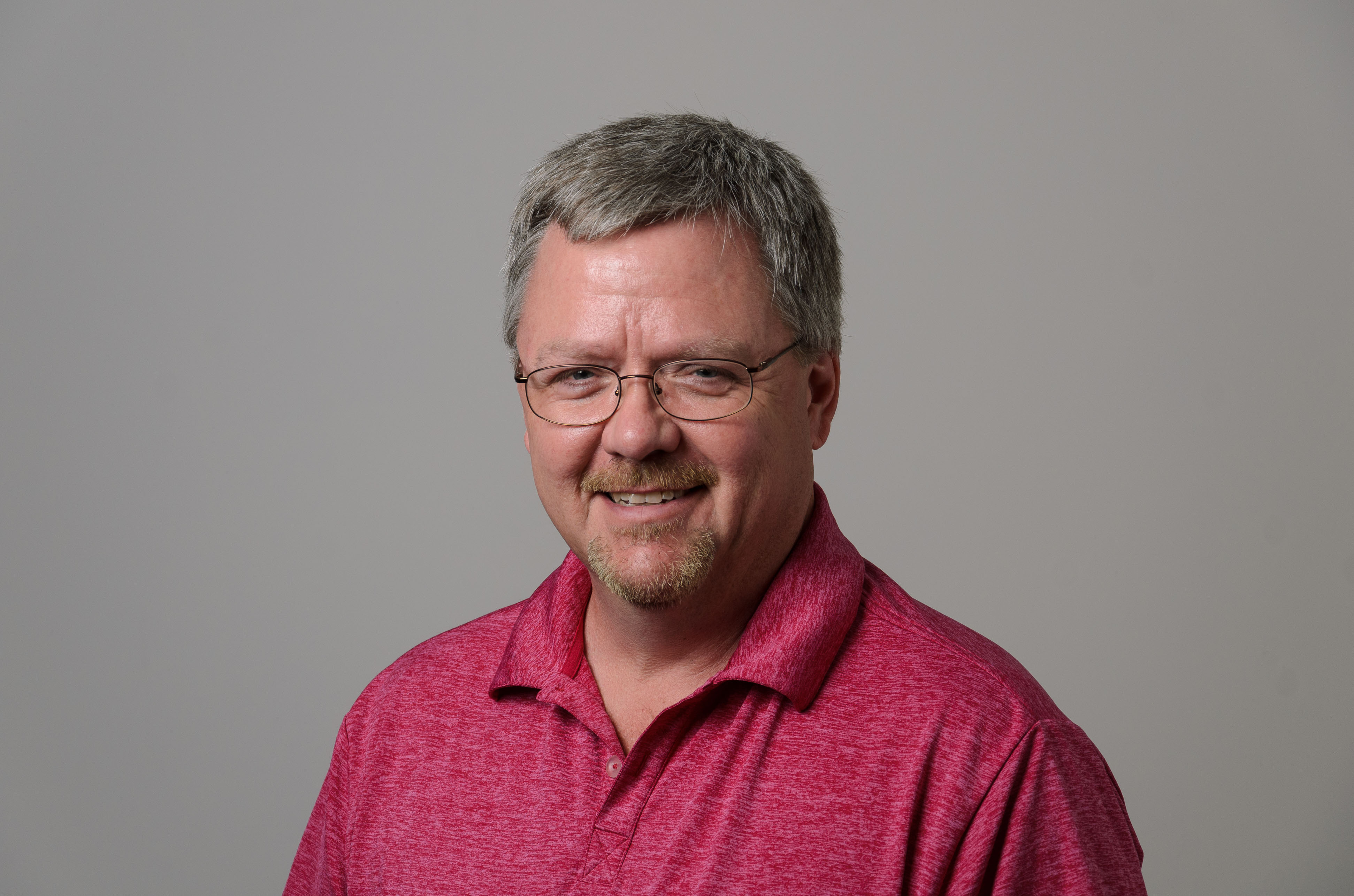 Headshot of William Field. Red Shirt.